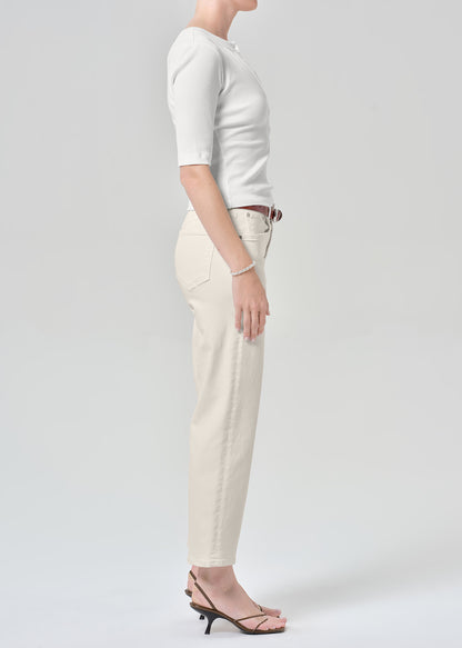 Persson wearing a white top with almond colored ankle jeans
