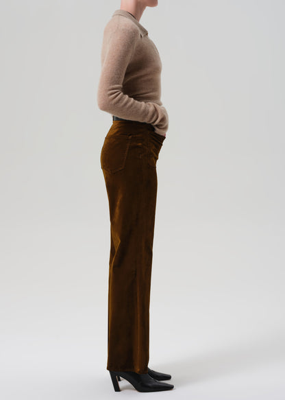 Person wearing a beige sweater and brown velvet flare-leg pants on a grey background
