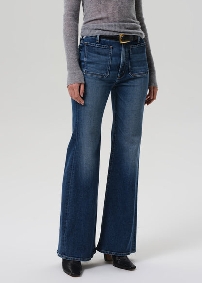 Person wearing blue flared jeans on a white background