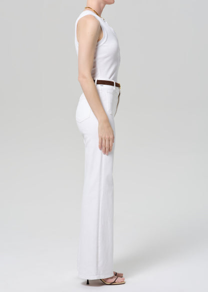 Person wearing a white sleeveless top and pants on a plain background