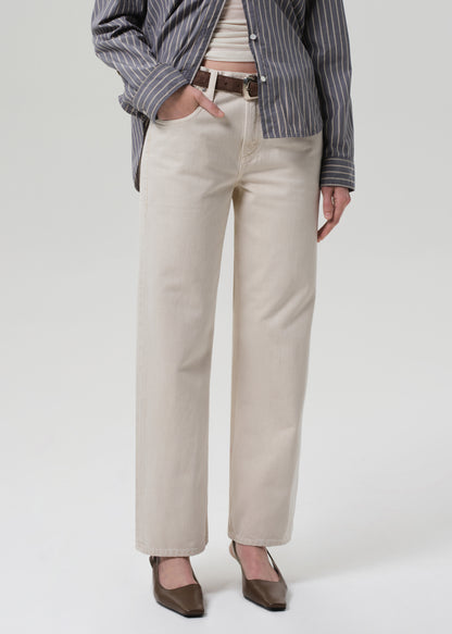 Person wearing beige pants with a striped shirt on a white background