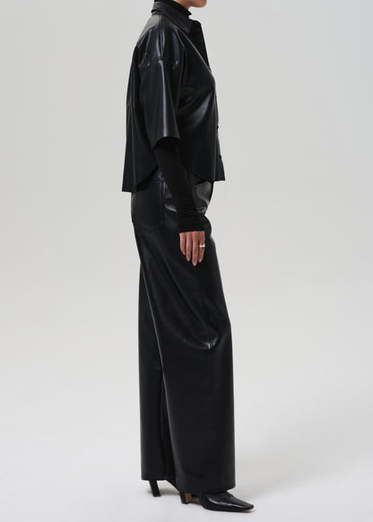 Person wearing a black leather outfit on a grey background