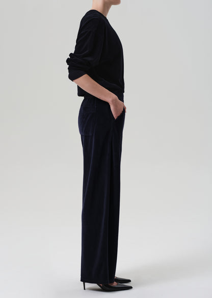 Person wearing a navy velvet set with wide-leg pants on a grey background