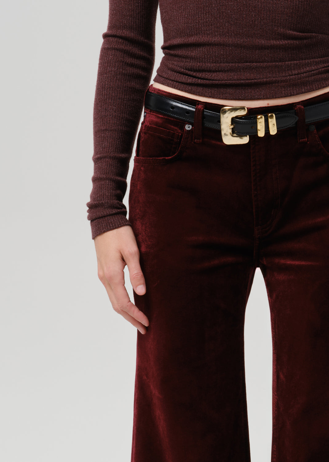 Close-up of burgundy wide leg pants on a grey background