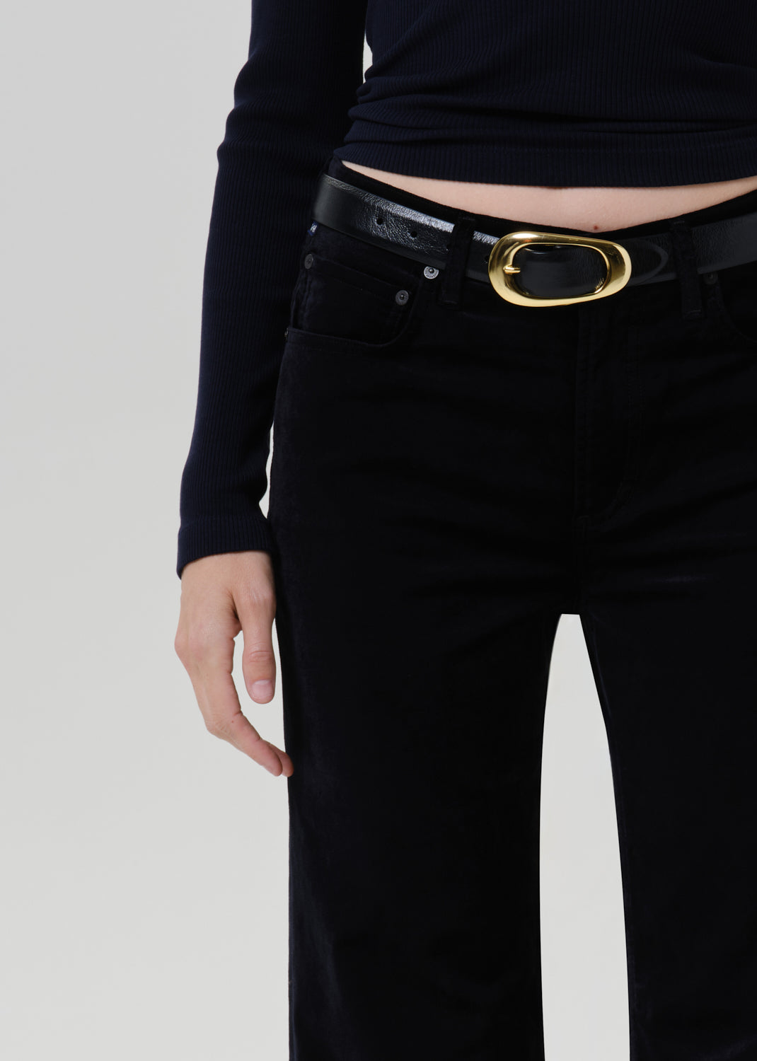 Close-up of black wide leg trousers on a grey background