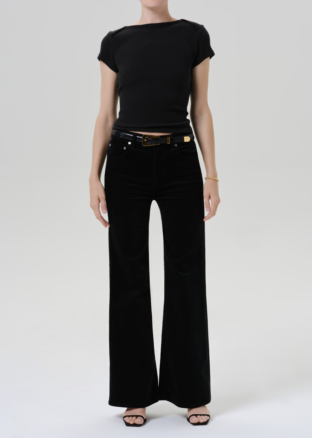 Person wearing a black outfit on a grey background