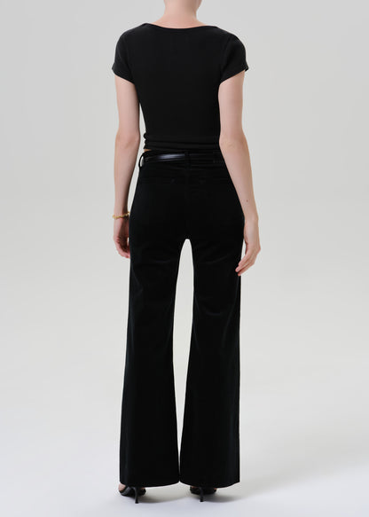 Person wearing a black outfit on a grey background