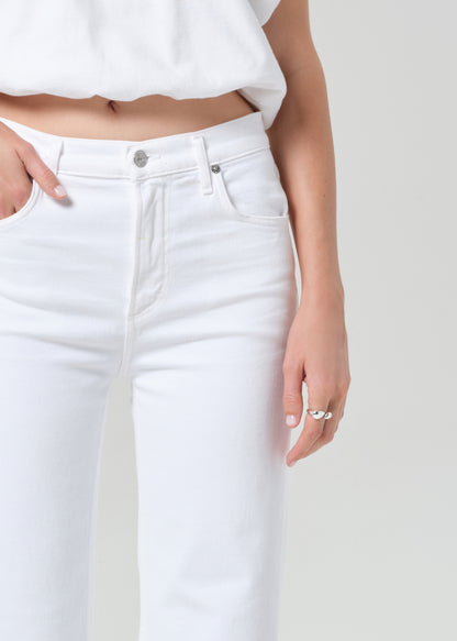Person wearing a white shirt and white jeans on a plain background