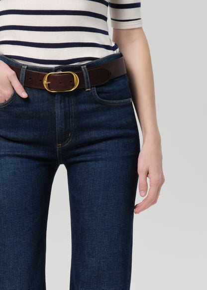 Person wearing a striped shirt and blue jeans on a plain background