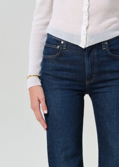 Person wearing white cardigan and dark blue jeans