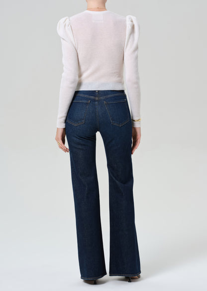 Person wearing white cardigan and dark blue jeans