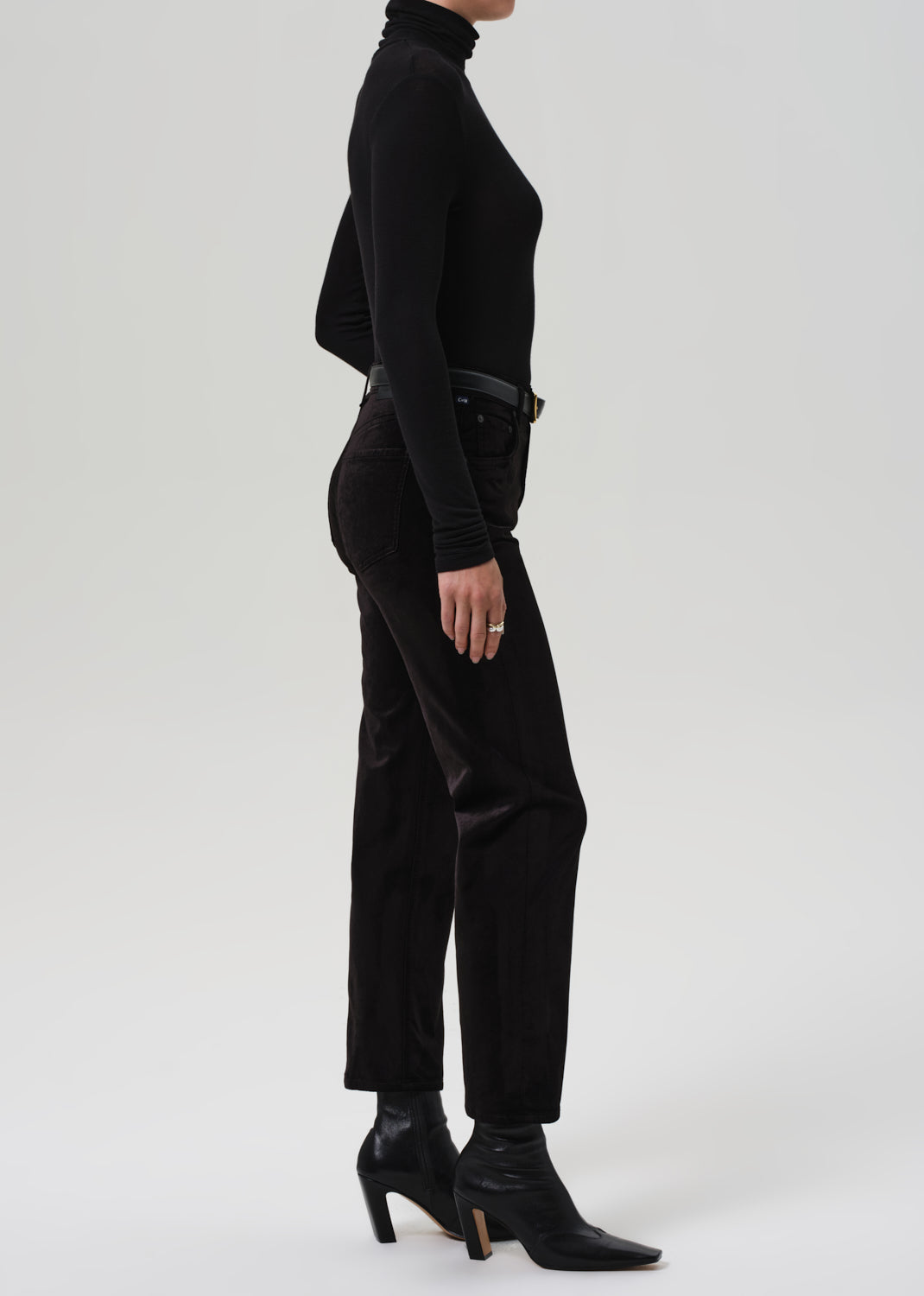 Person wearing a black turtleneck and black pants on a white background