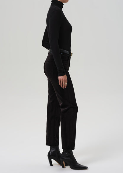 Person wearing a black turtleneck and black pants on a white background
