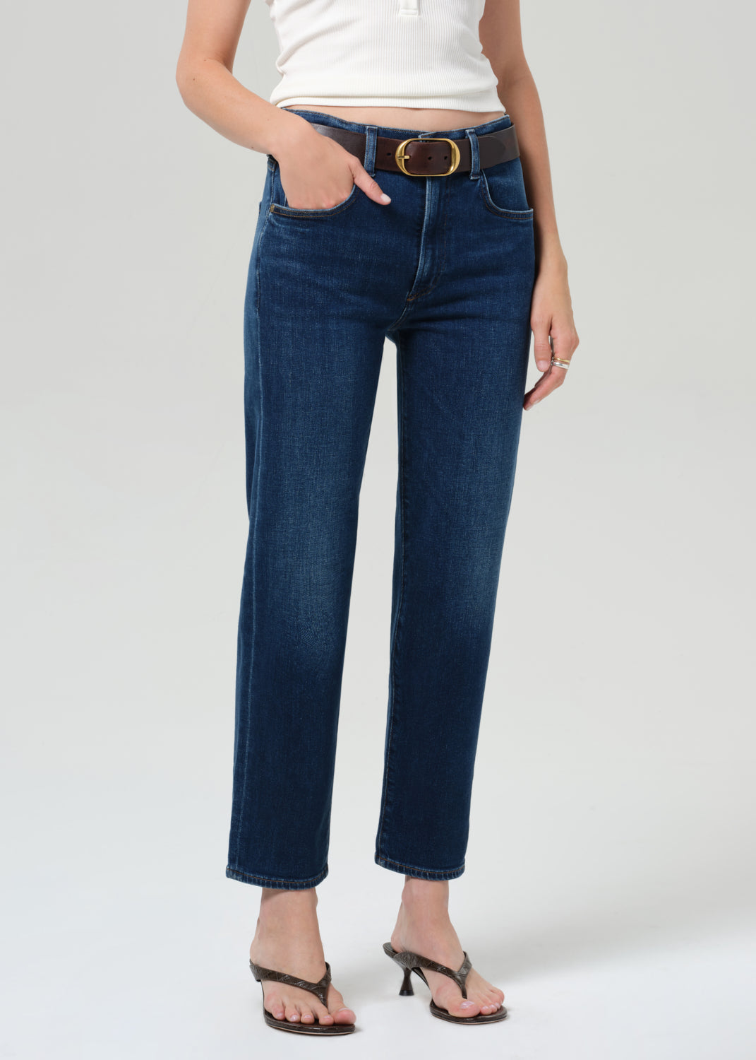 Person wearing blue jeans with a grey background