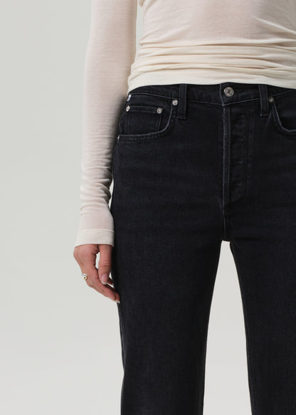 Person wearing black jeans and a white long-sleeve shirt on a plain background