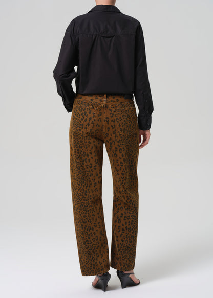 Person wearing a black shirt and brown cheetah print pants on a white background