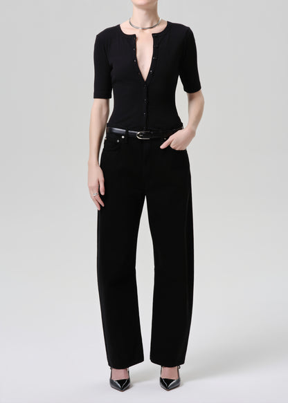 Person wearing a black outfit with a grey background