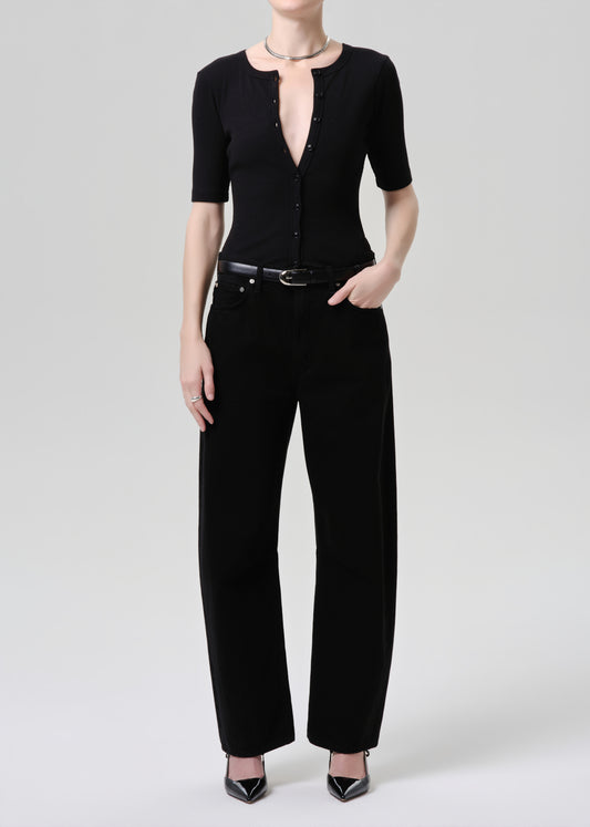 Person wearing a black outfit with a grey background