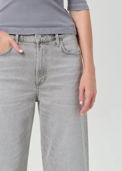 Person wearing light gray jeans on a plain background