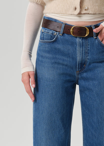 Close up of blue pant and brown belt on grey background