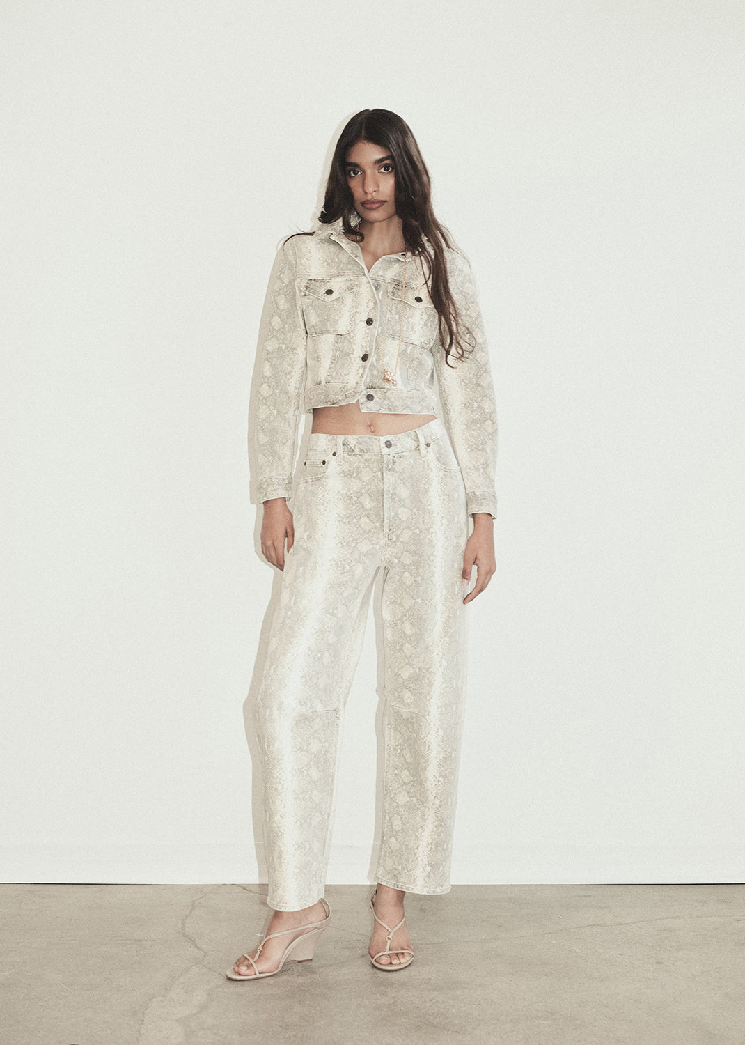 Woman wearing a matching python patterned outfit against a plain background