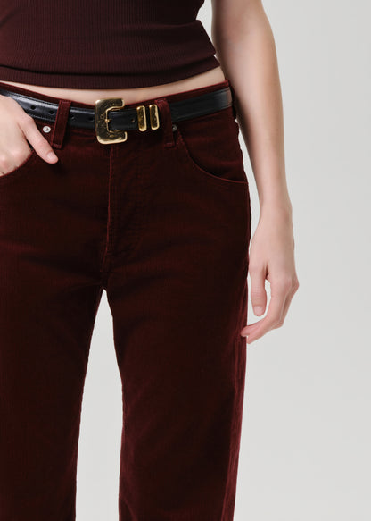 Brown pants with a black belt on a grey background