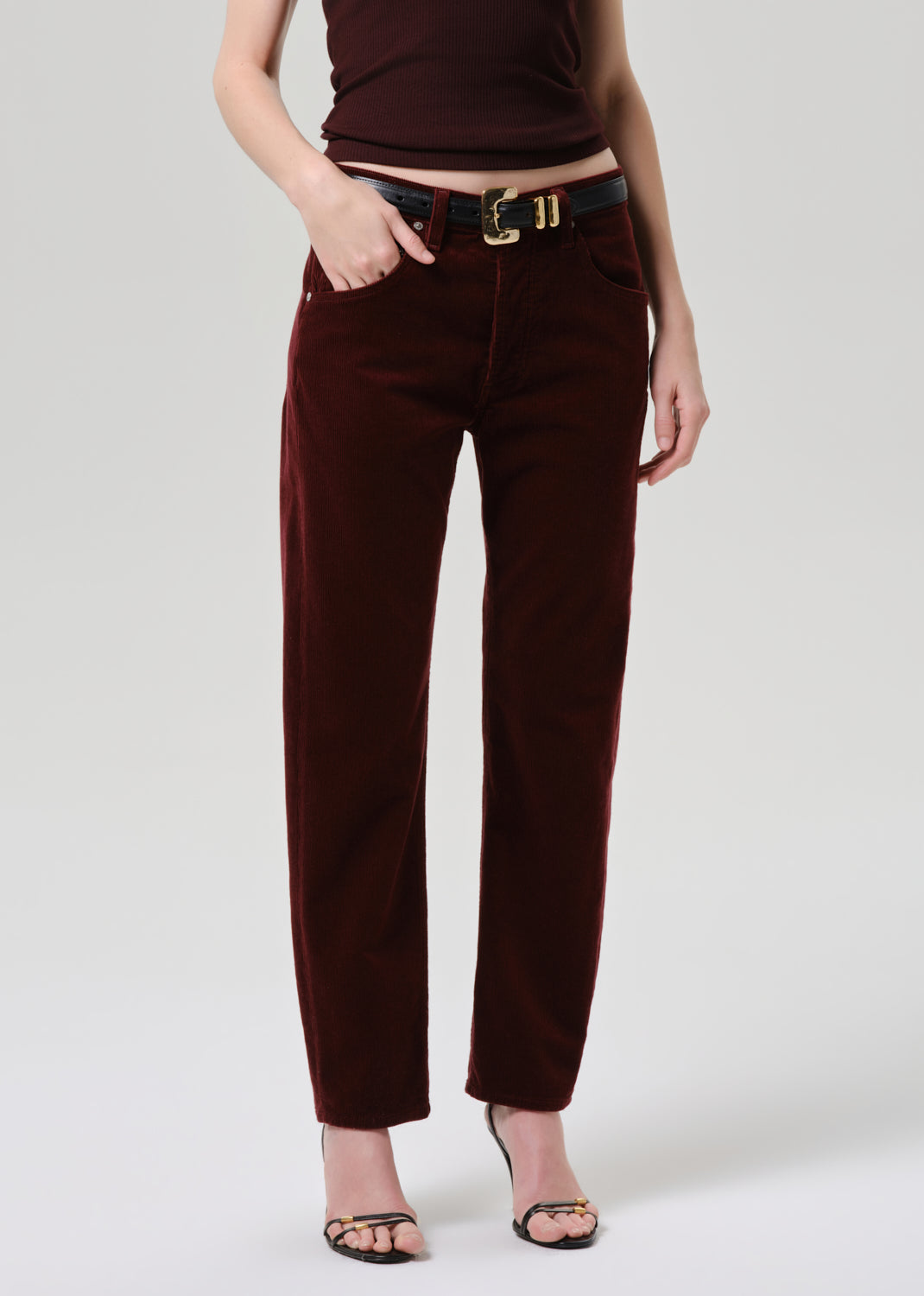 Person wearing brown pants and a matching top on a grey background