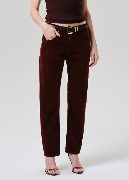 Person wearing brown pants and a matching top on a grey background
