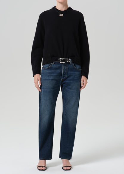 Person wearing dark indigo jeans paired with sweater