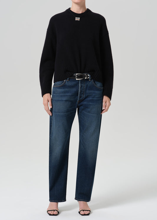 Person wearing dark indigo jeans paired with sweater