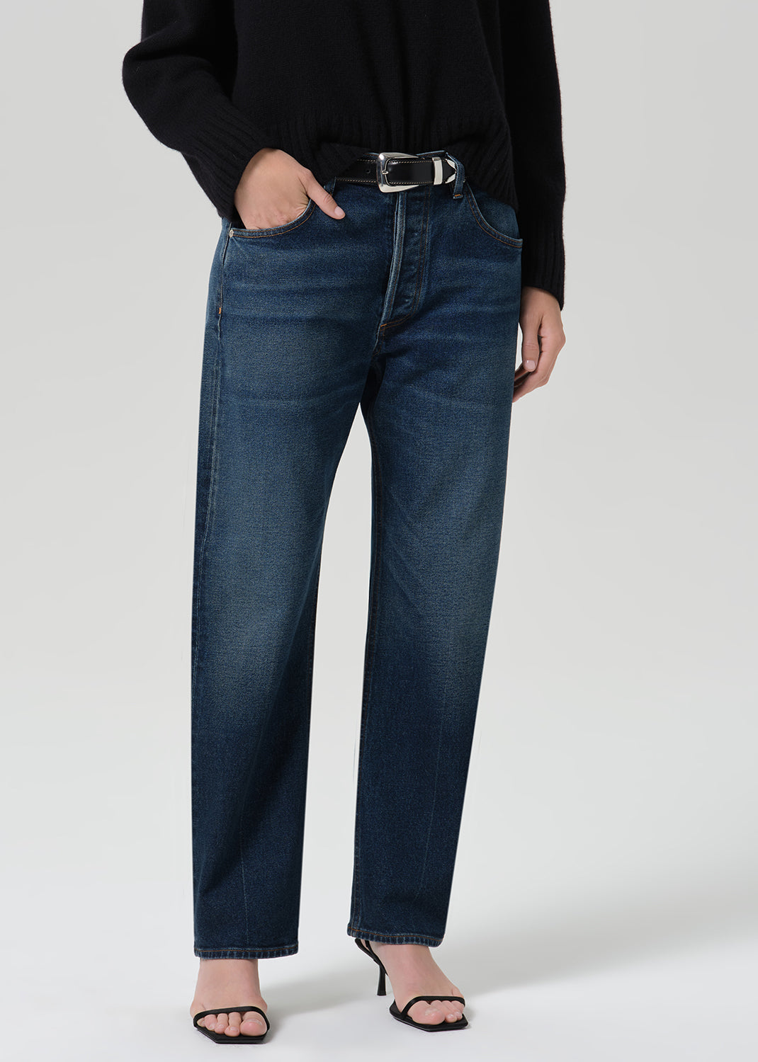Person wearing dark indigo jeans paired with sweater