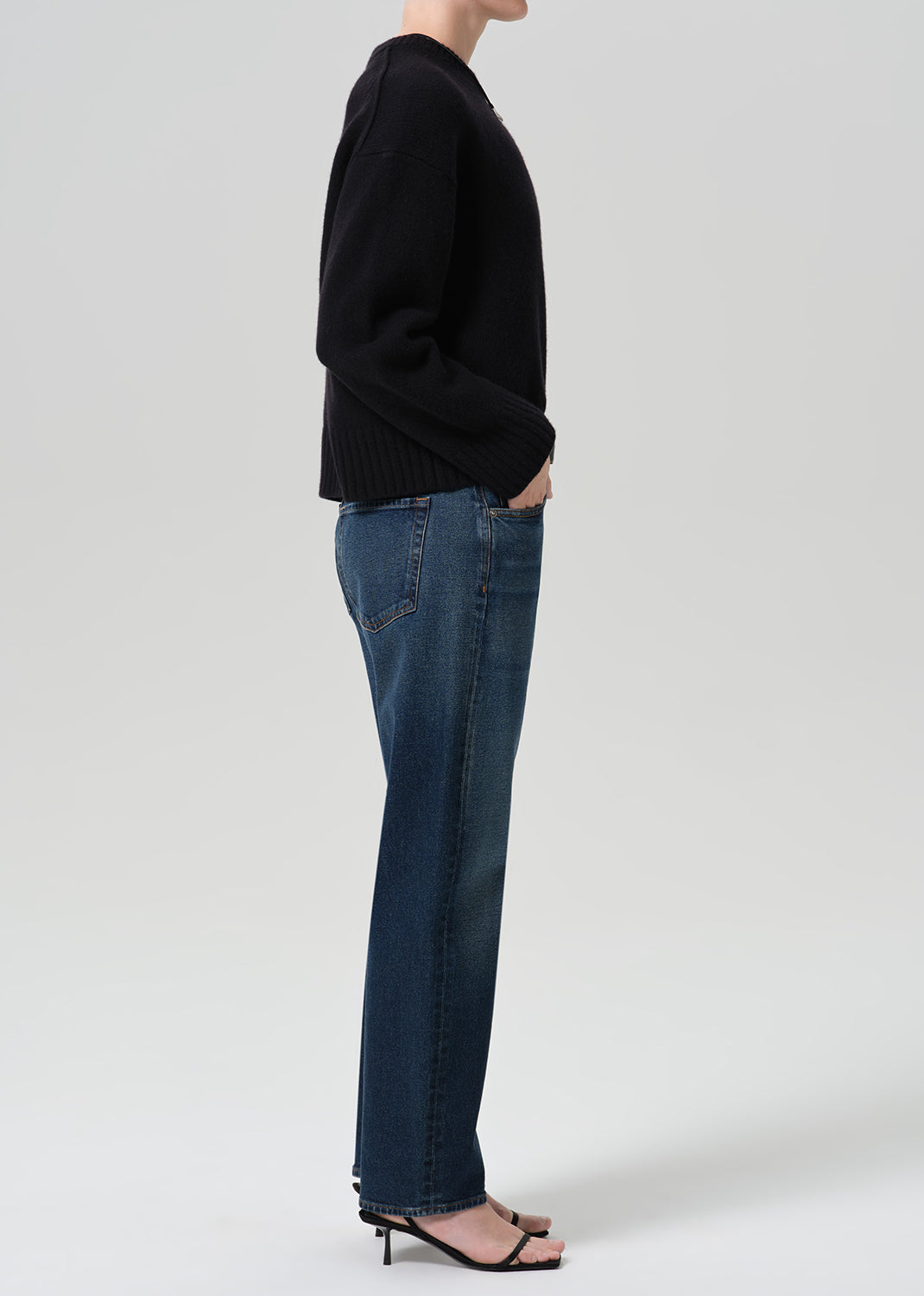 Person wearing dark indigo jeans paired with sweater