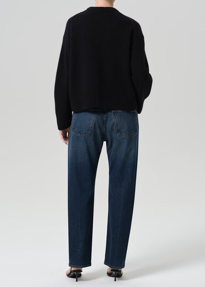 Person wearing dark indigo jeans paired with sweater