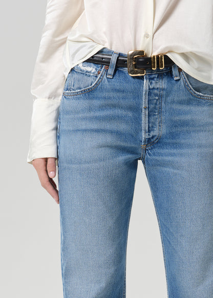 Person wearing medium indigo jeans paired with cream color shirt