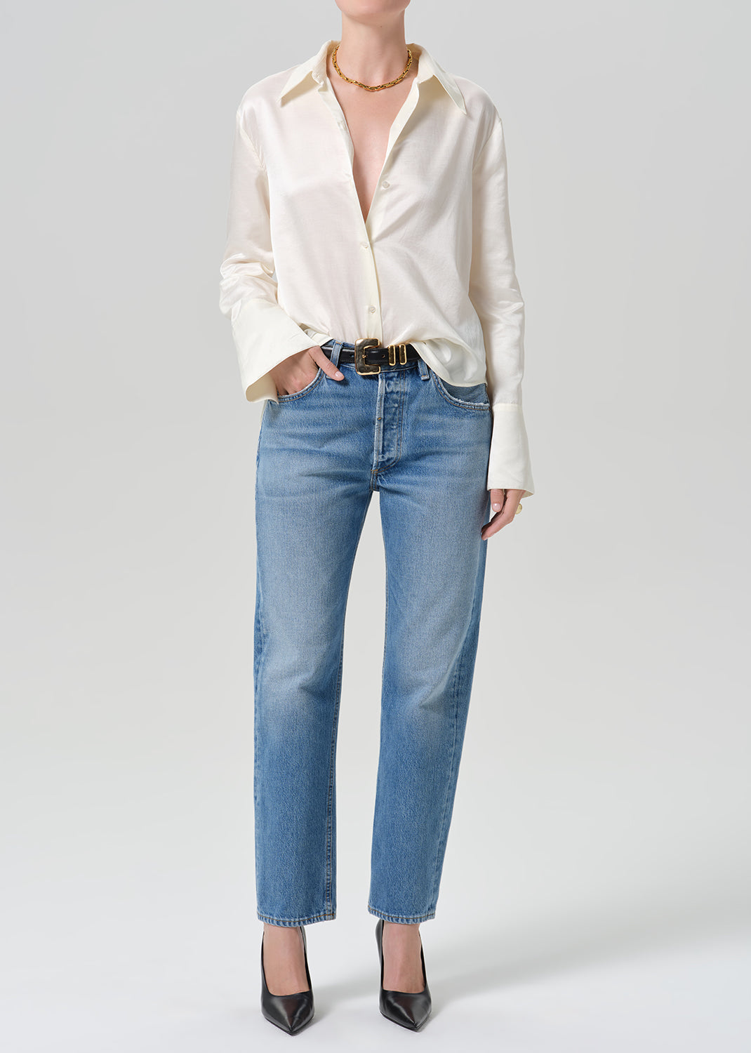 Person wearing medium indigo jeans paired with cream color shirt