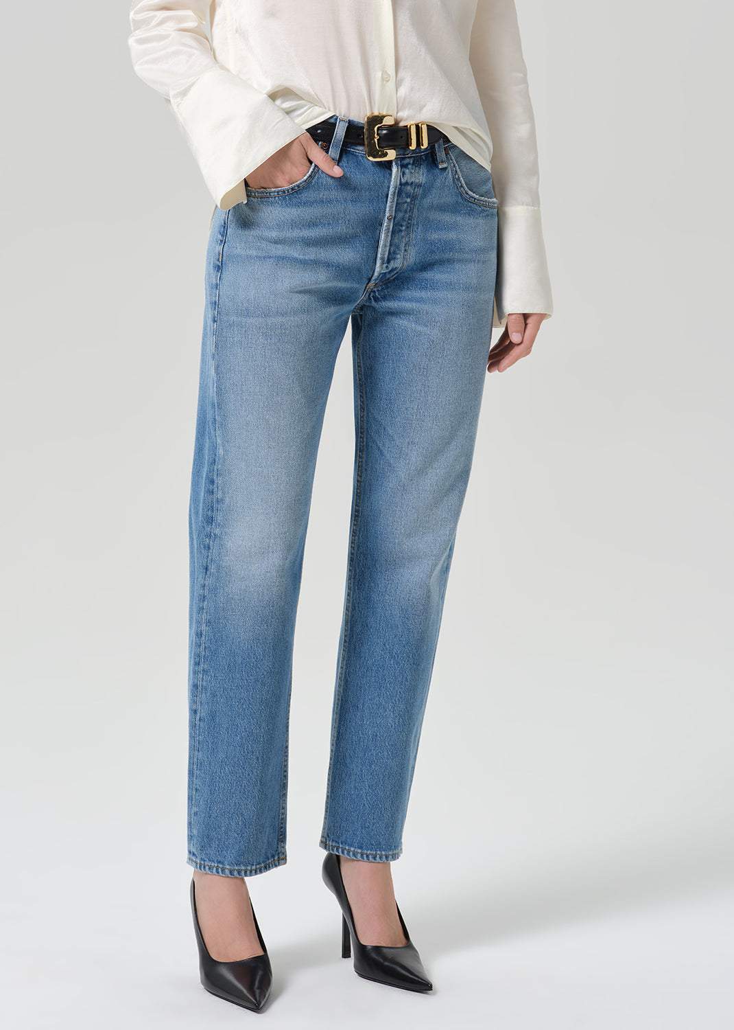 Person wearing medium indigo jeans paired with cream color shirt
