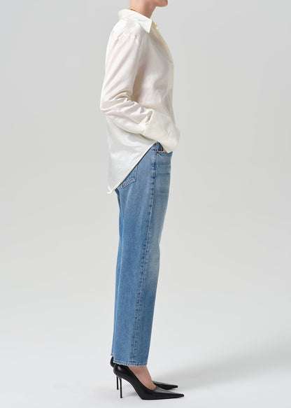 Person wearing medium indigo jeans paired with cream color shirt
