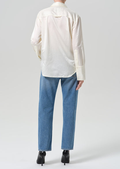 Person wearing medium indigo jeans paired with cream color shirt