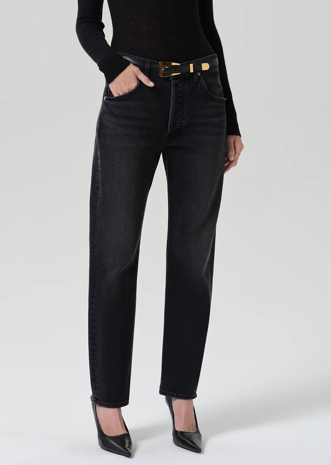 Person wearing washed black jeans paired with black turtleneck