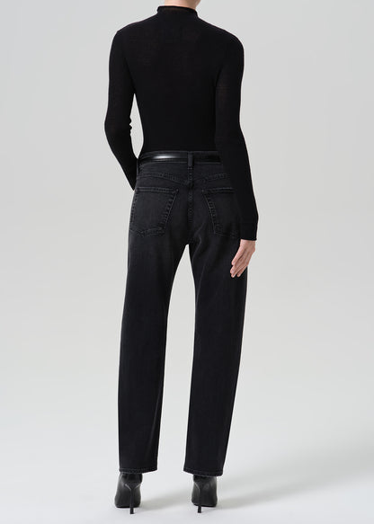 Person wearing washed black jeans paired with black turtleneck