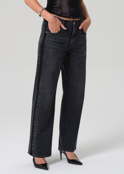 Person wearing black jeans on a grey background