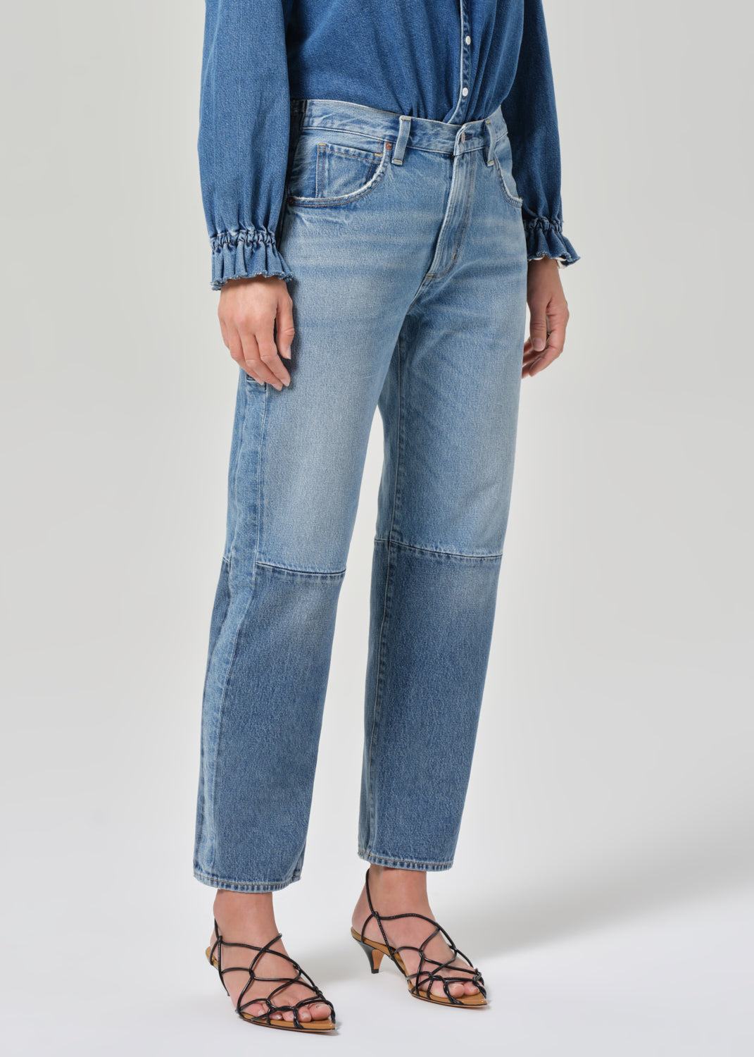 Person wearing blue jeans and a blue shirt on a white background