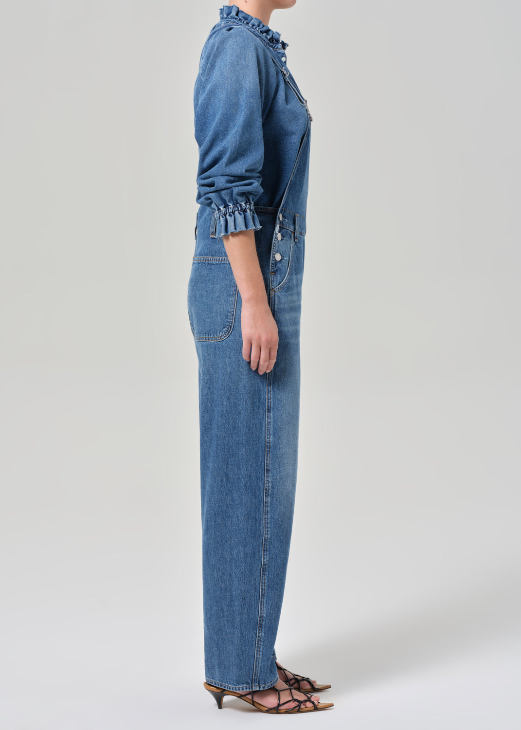 Person wearing a blue denim outfit on a white background