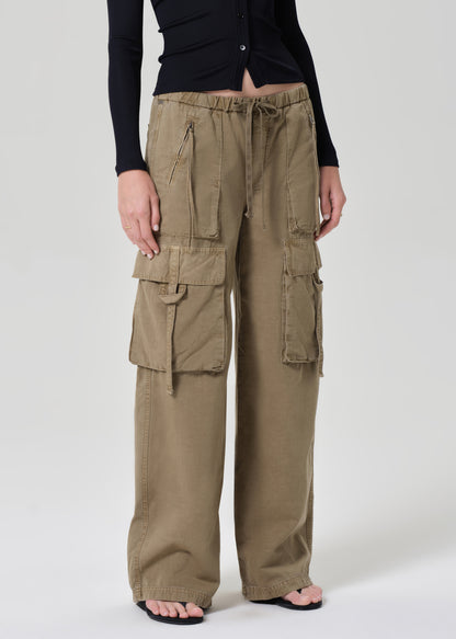 Person wearing a black shirt and beige cargo pants on a plain background