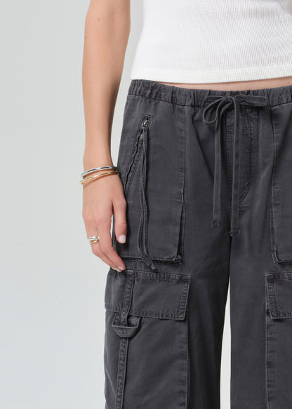 Person wearing a white tee with dark gray cargo pants on a plain background