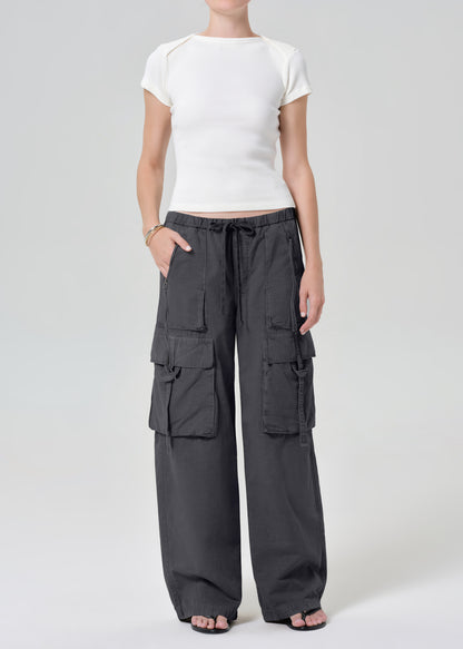 Person wearing a white tee with dark gray cargo pants on a plain background
