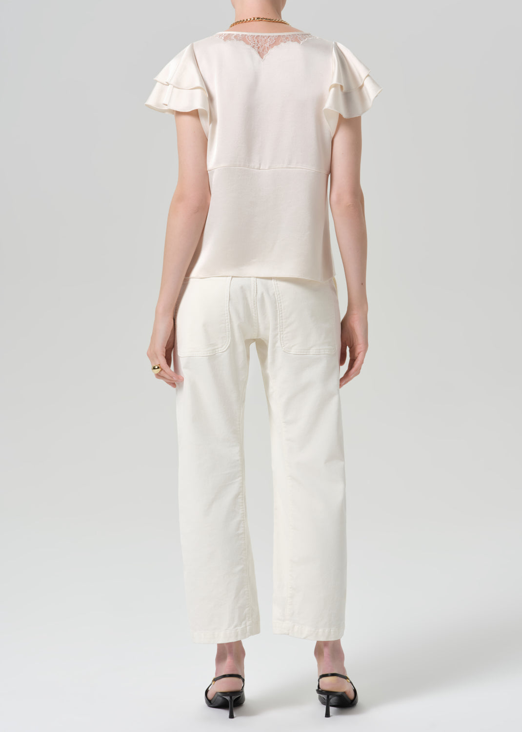 Person wearing a white outfit on a grey background