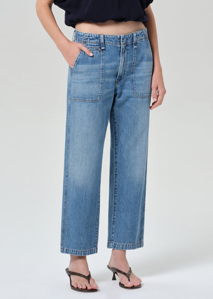 Person wearing blue jeans on a grey background