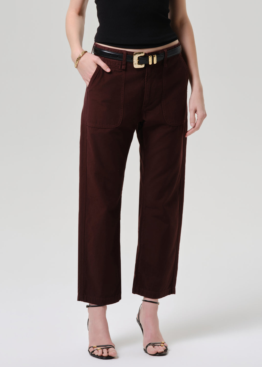 Brown pants worn by a person on a grey  background