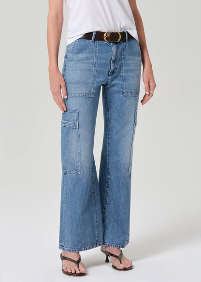 Person wearing a white t-shirt and blue jeans with a belt on a plain background